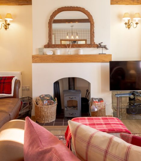 Cosy cottage living room with log burner in a Red Kite Hosts managed holiday let in the Cotswolds